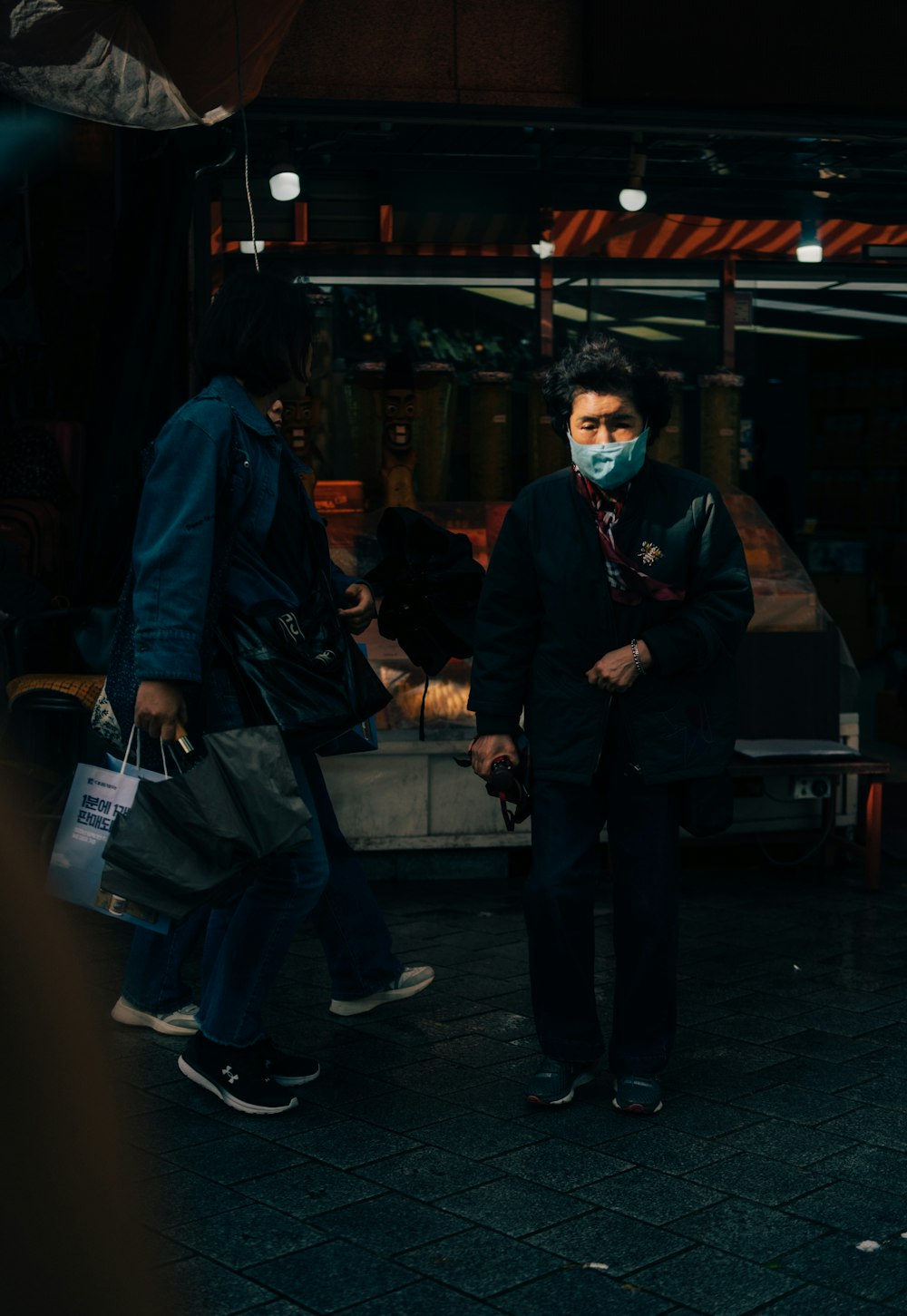 a man wearing a face mask standing on a sidewalk