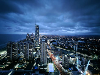 A dramatic aerial view of a cityscape captured by a flyfrogg cinematic drone at dusk.