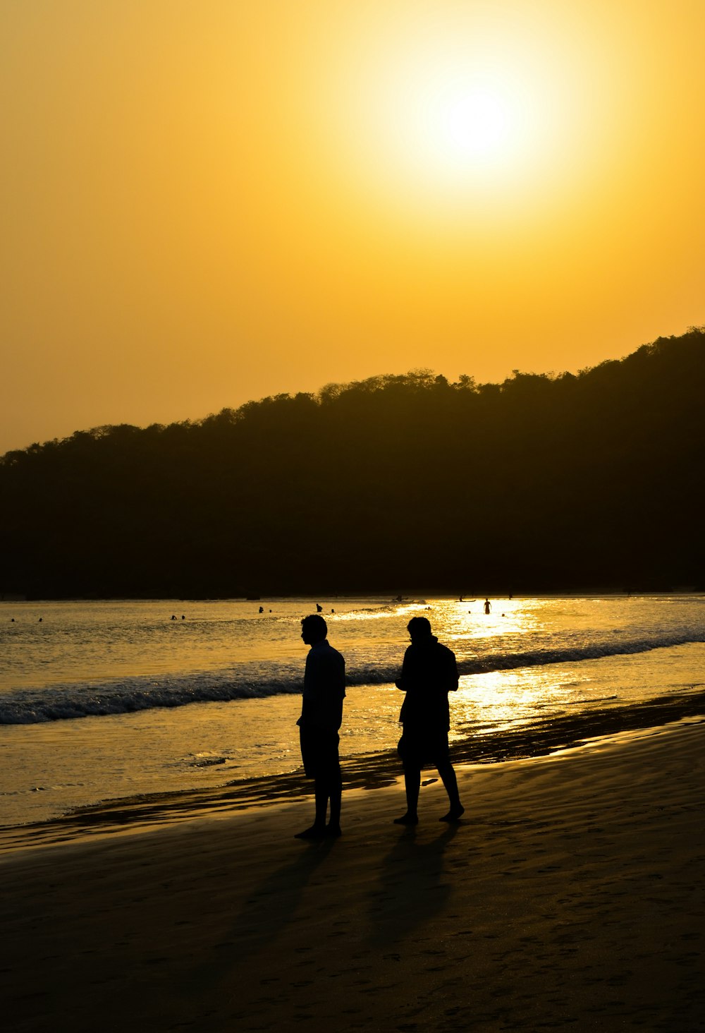 a couple of people standing on top of a beach