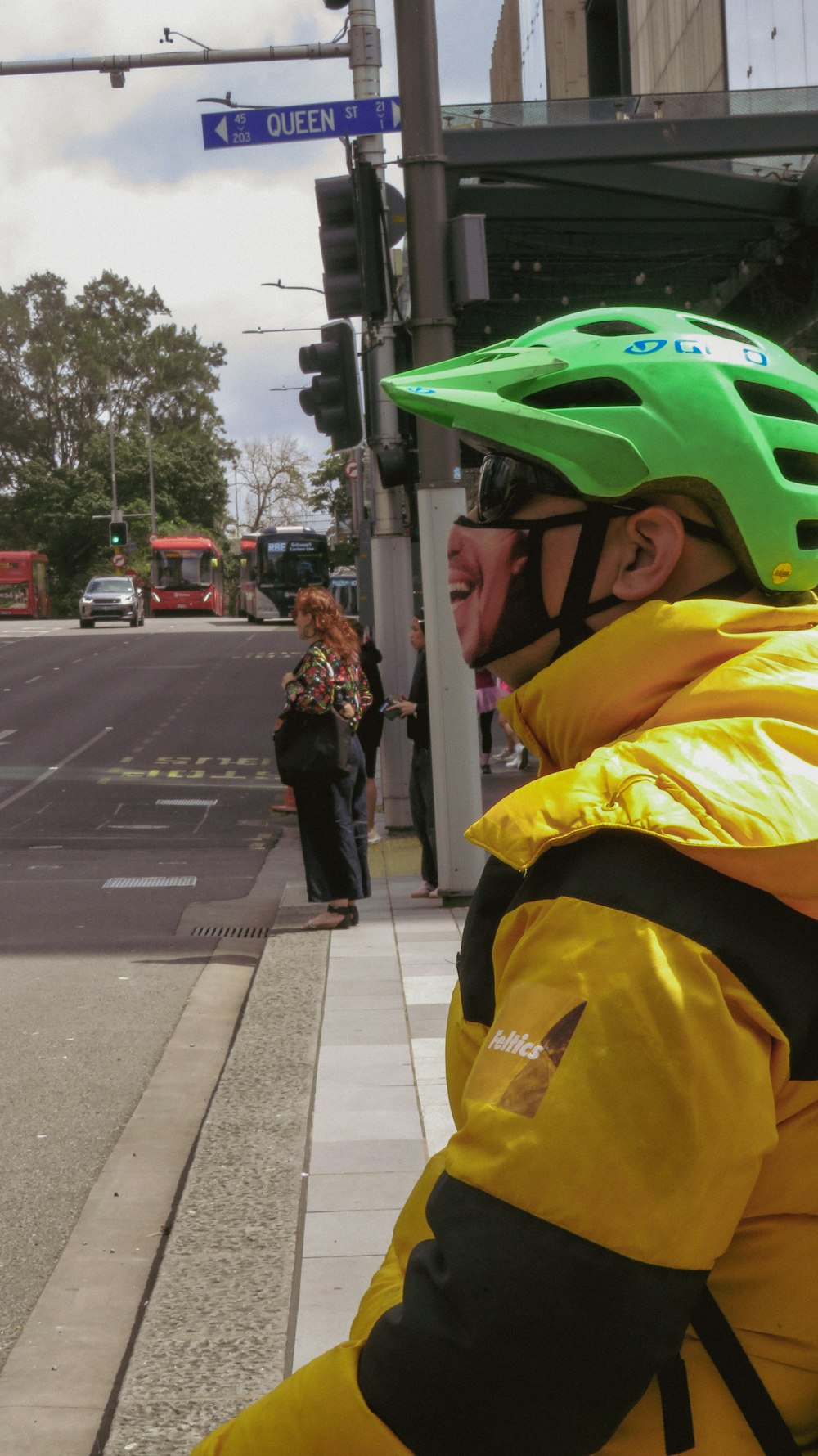 a man in a yellow and black jacket and a green helmet