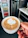 A happy customer holding a sleek, modern cup from Huojing in a cozy kitchen setting.