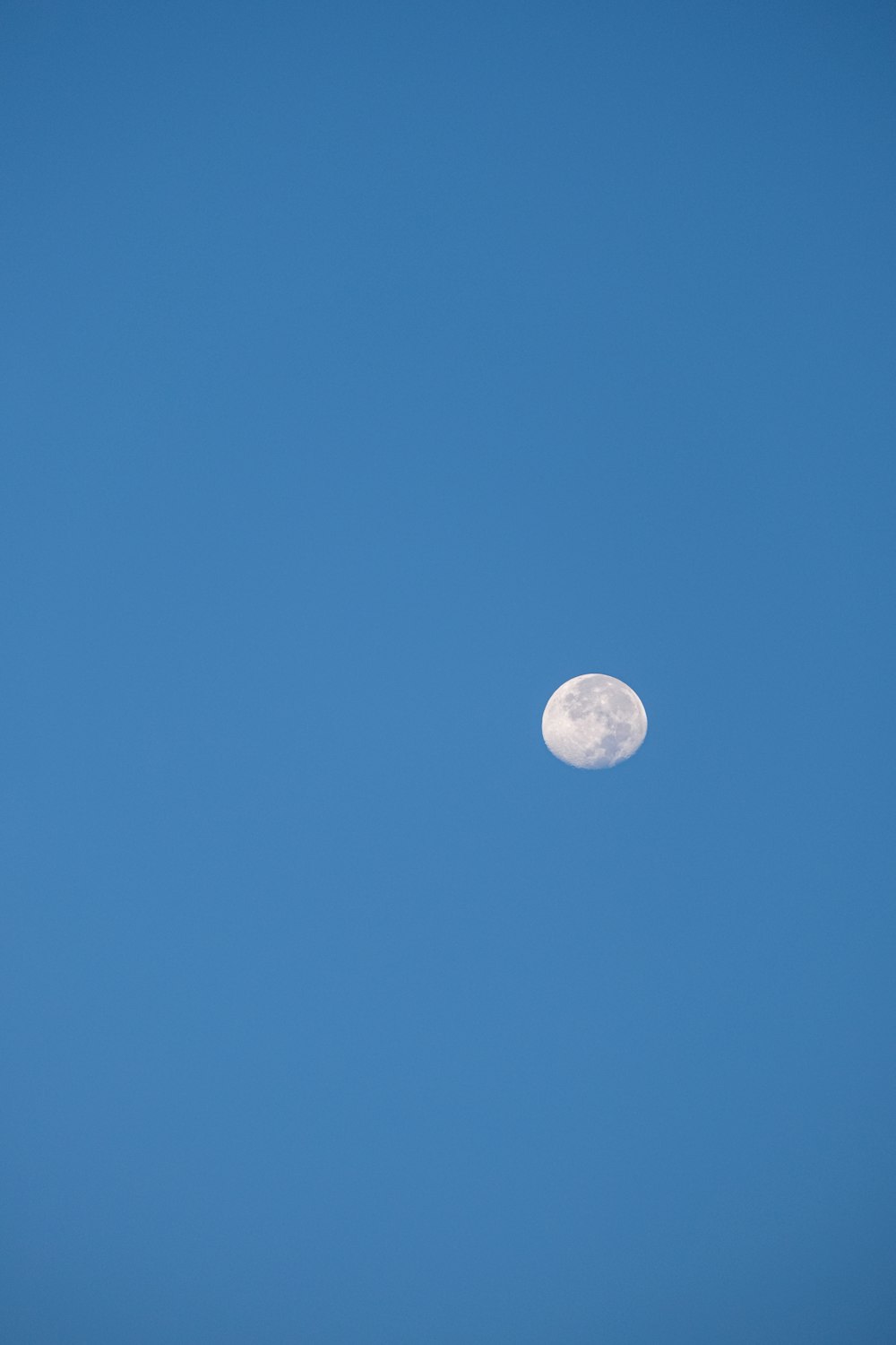 a full moon in a clear blue sky