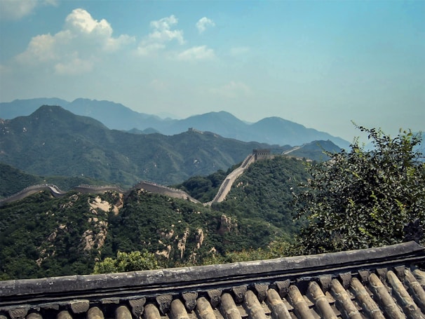 A panoramic shot of the Great Wall of China winding over misty mountains.