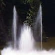 a group of fountains spewing water into a lake