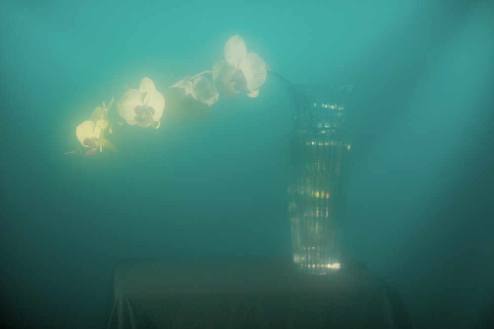 a tall glass vase sitting on top of a table