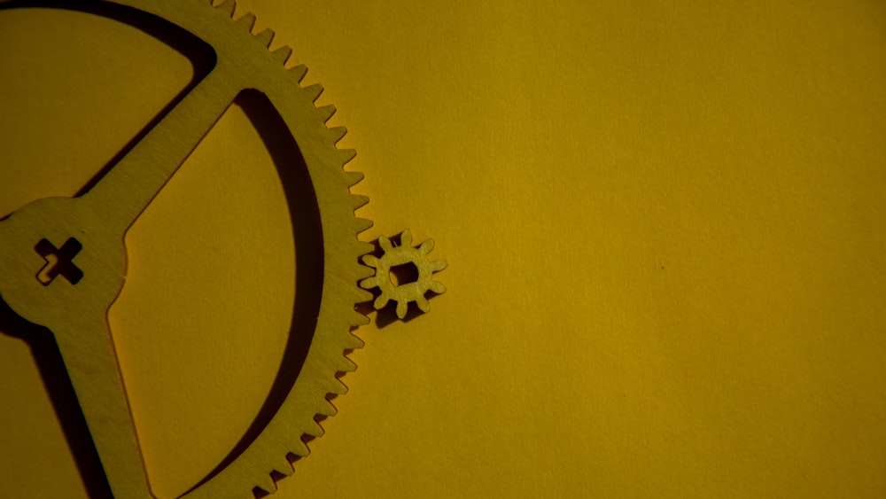 a close up of a clock on a yellow surface