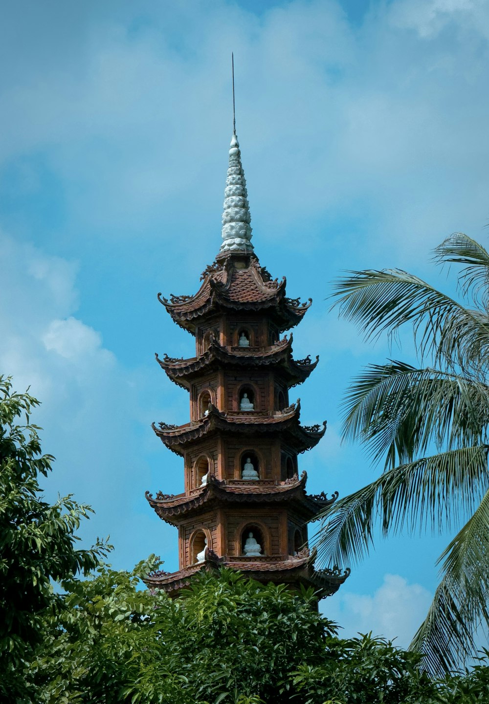 a tall tower with a white roof surrounded by trees