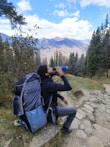A person carrying a sipro Travel Series bottle with a scenic mountain trail in the background