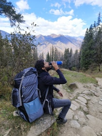 A hiker drinking from a himalpure bottle amidst the Himalayan mountains.