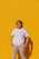 a woman standing in front of a yellow wall