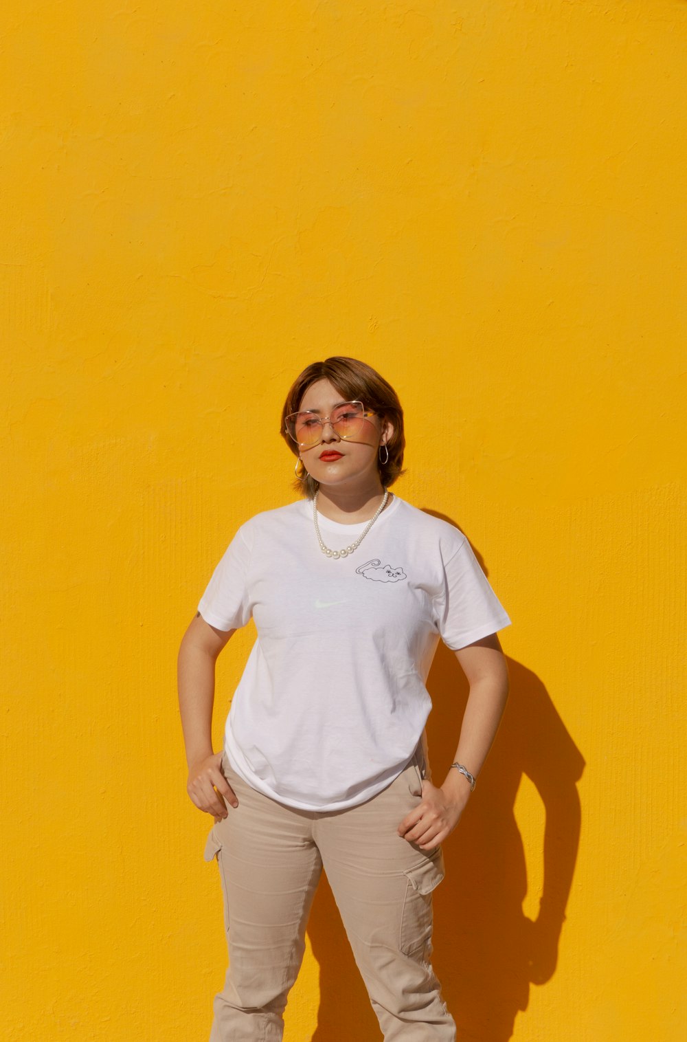 a woman standing in front of a yellow wall