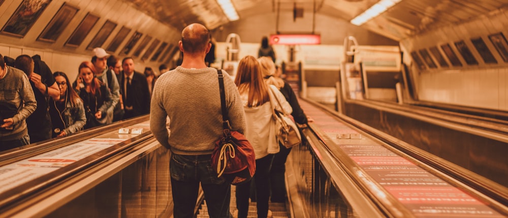 a group of people standing on an escalator in a train station