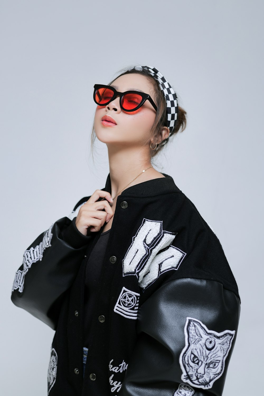 a woman wearing a black jacket and red sunglasses