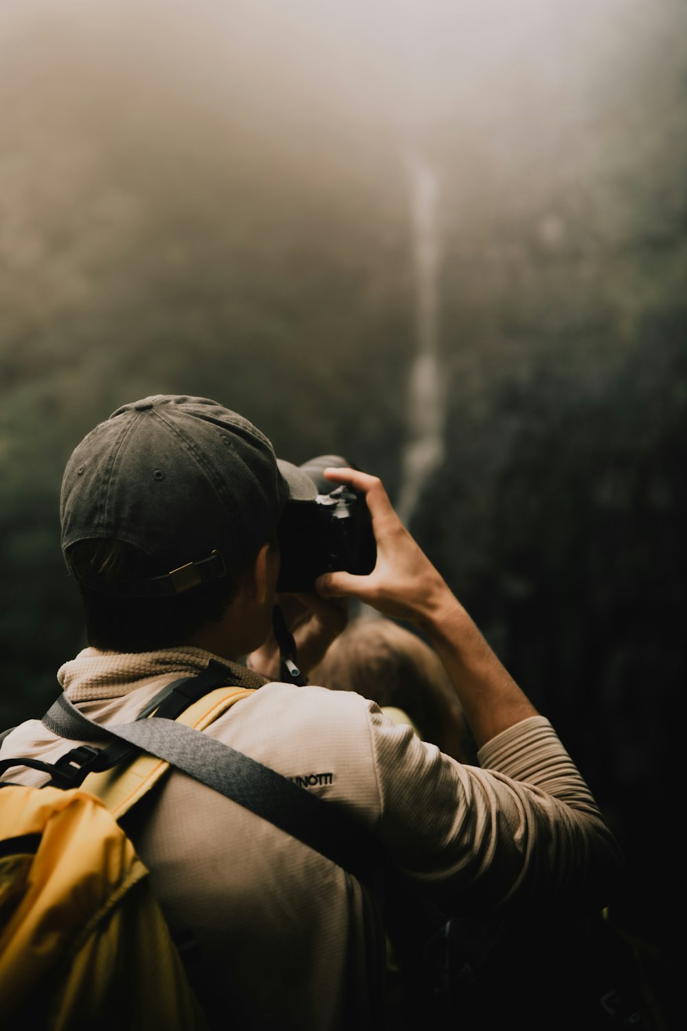 a man with a backpack taking a picture with a camera