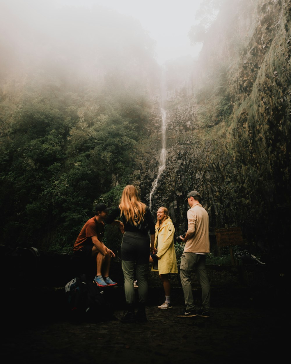 a group of people standing in front of a waterfall