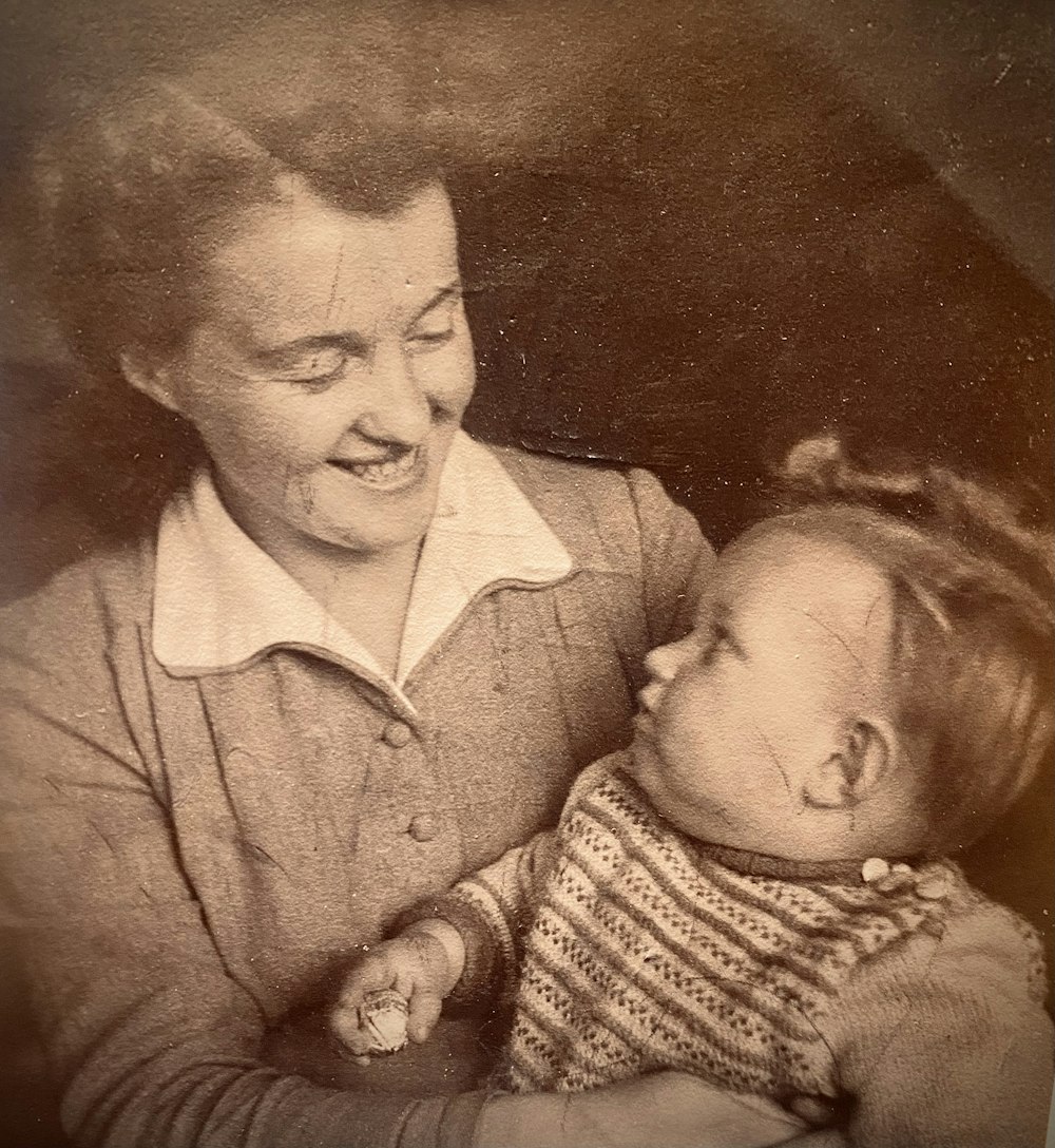 an old photo of a woman holding a baby