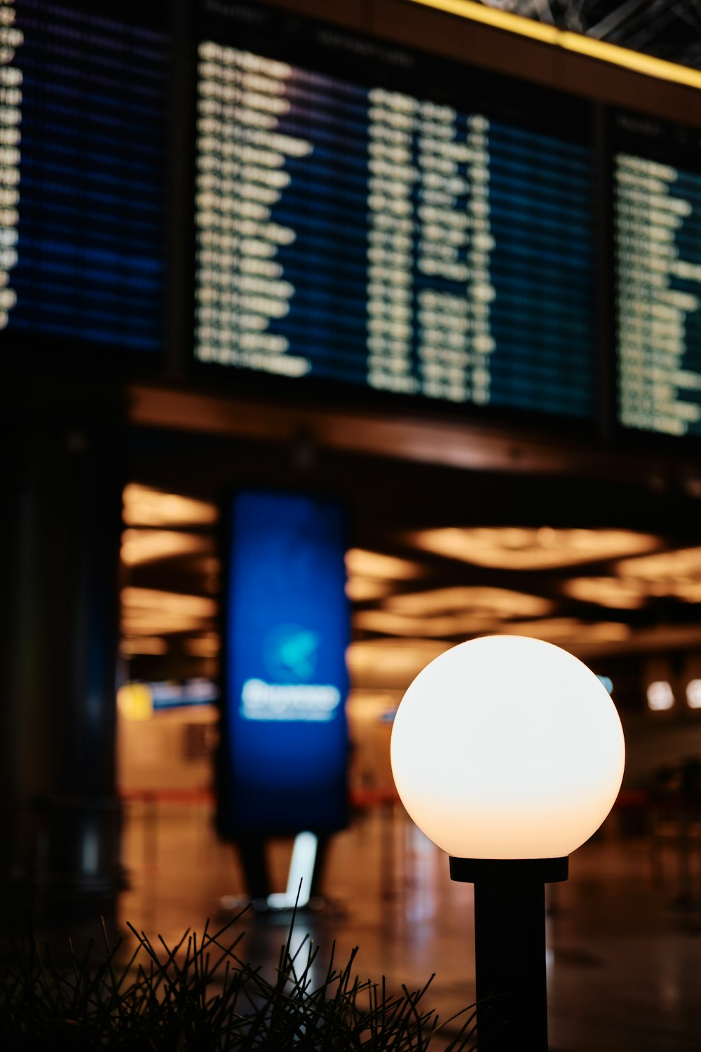a white light sitting in front of an airport sign