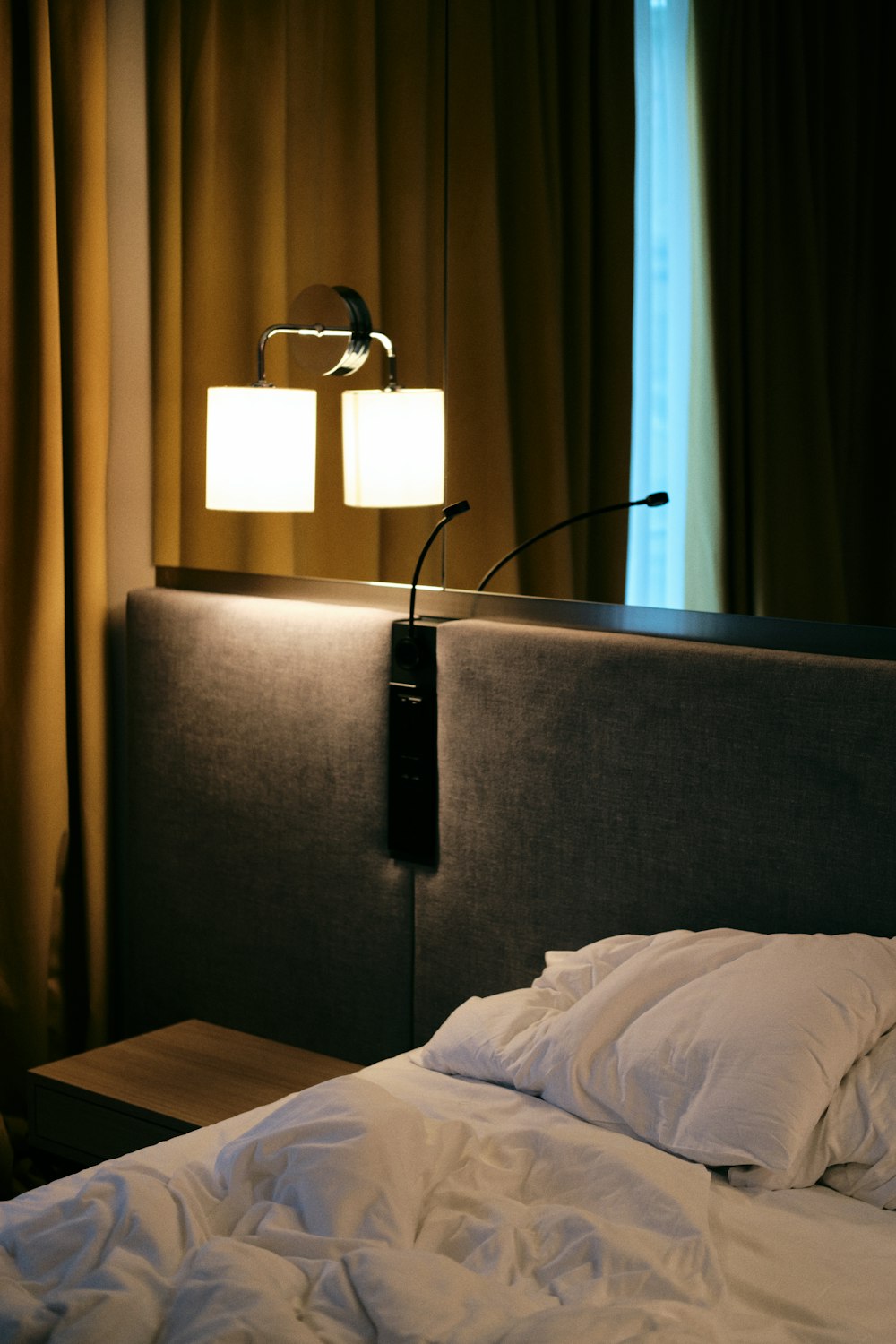 a bed with a white comforter and two lamps