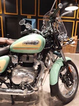 A rugged mechanic’s workspace with Royal Enfield parts laid out neatly under warm workshop lighting.