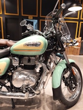 A technician changing oil on a classic Royal Enfield bike in a clean workshop