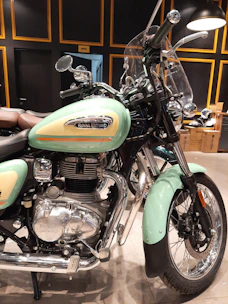 A gleaming Royal Enfield motorcycle displayed prominently in a stylish showroom.