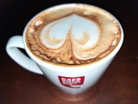 A vibrant coffee cup with latte art on a cafe table.