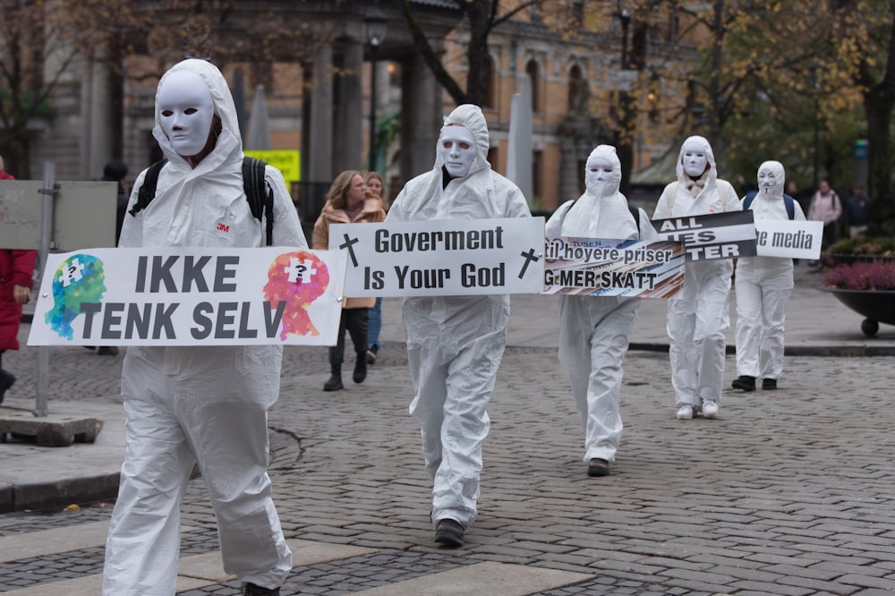 a group of people walking down a street holding protest signs