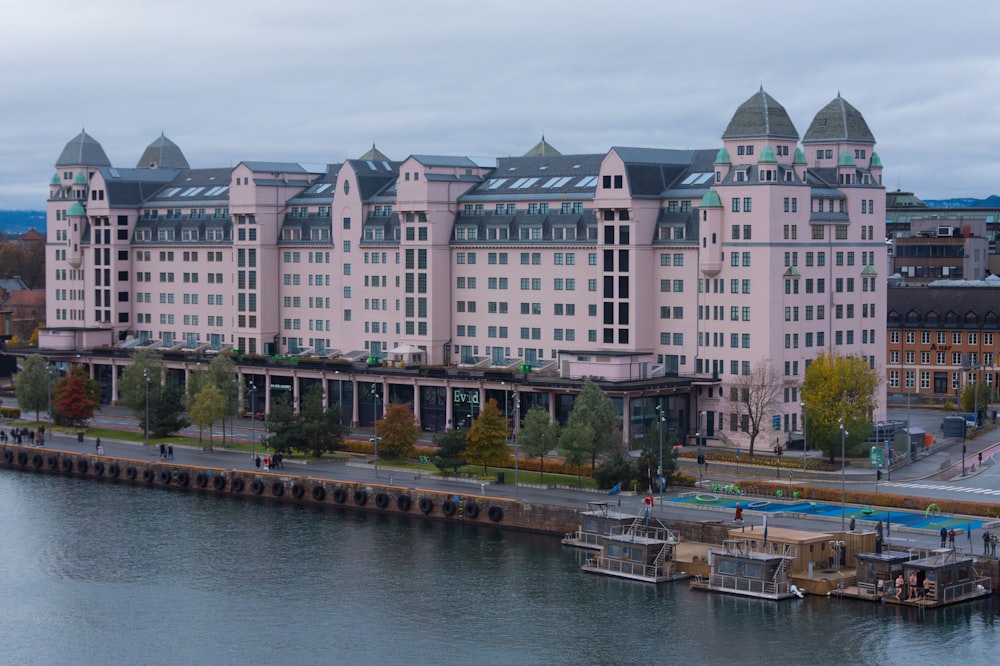 a large pink building next to a body of water