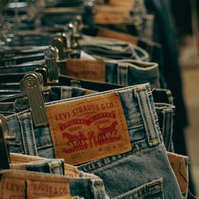 A row of blue jeans hanging on a rack at a secondhand market in Seoul