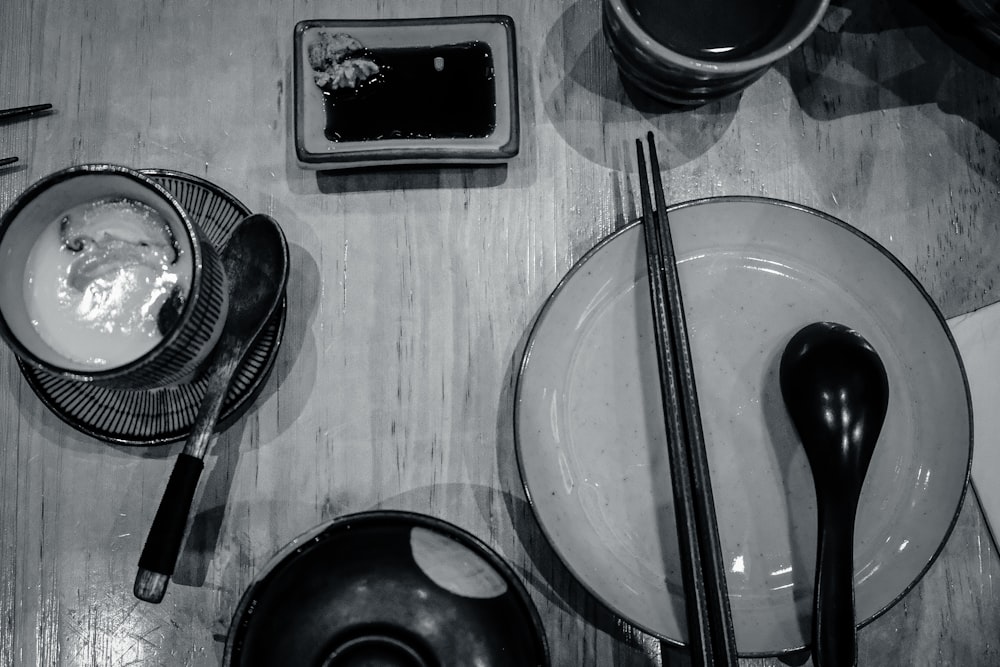 a wooden table topped with dishes and utensils