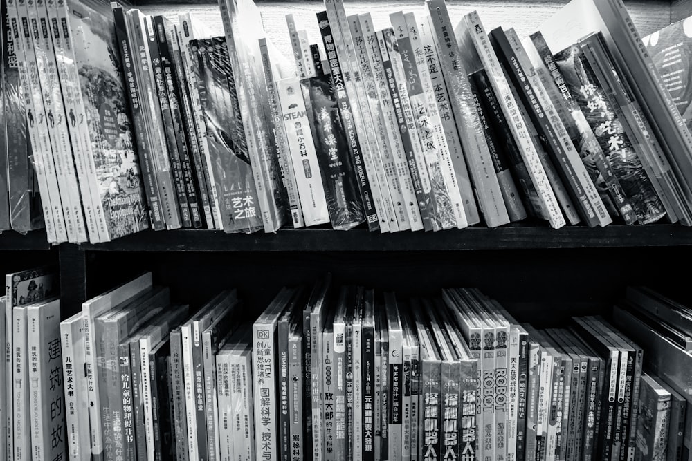 a black and white photo of a book shelf filled with books