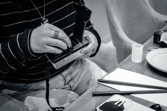 An artist carefully preparing a tintype plate in a rustic studio setting.