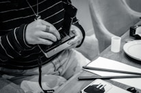 Hands carefully loading 120 film into a classic film camera in a cozy, warmly lit room.