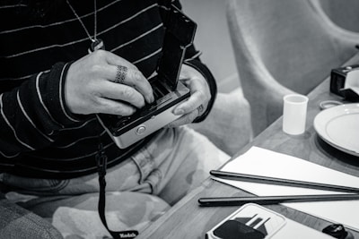 An artist carefully preparing a tintype plate in a rustic studio setting.