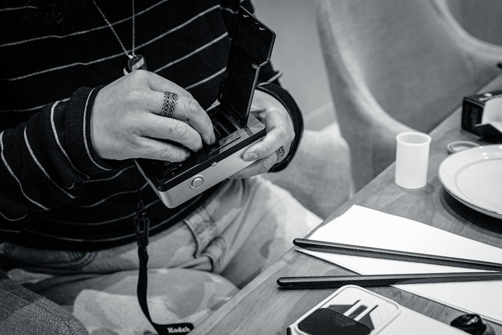 a person sitting at a table using a cell phone