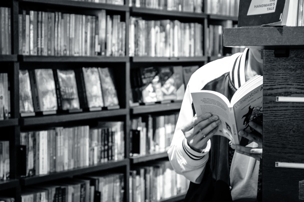 a woman reading a book in a library