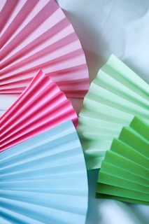 Brightly colored cartolina sheets arranged in a fan shape