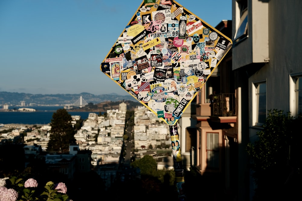 a street sign covered in stickers in front of a city