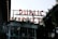 Large neon letters spell out 'PUBLIC MARKET' above a building filled with windows. Greenery and plants are visible around the structure, adding a natural element. The setting appears urban, with an industrial and welcoming atmosphere.