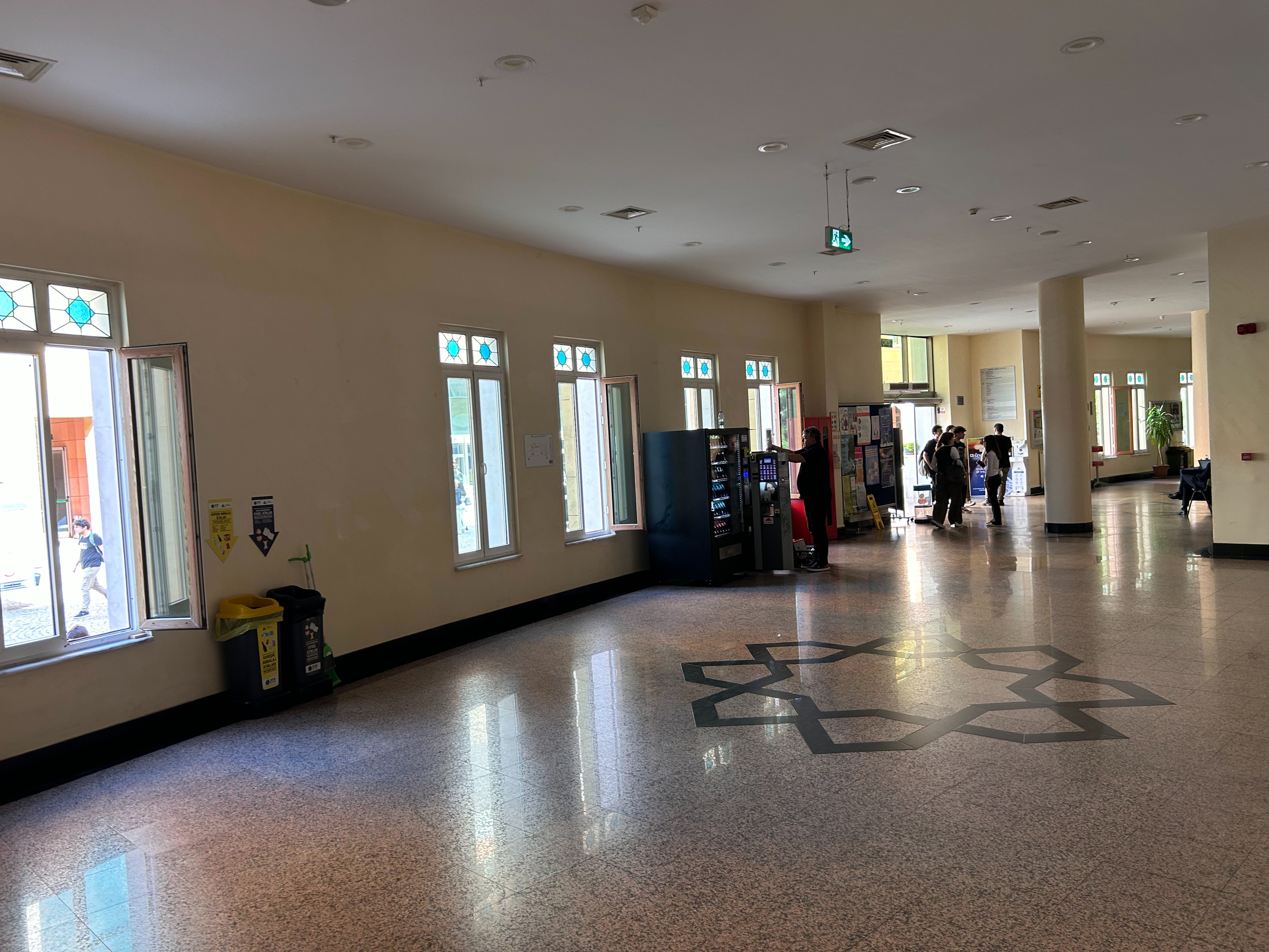 Modern vending machine in a college corridor with students nearby