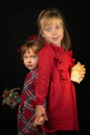 two little girls holding hands and posing for a picture