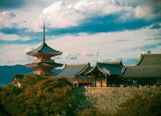 a tall building sitting on top of a lush green hillside