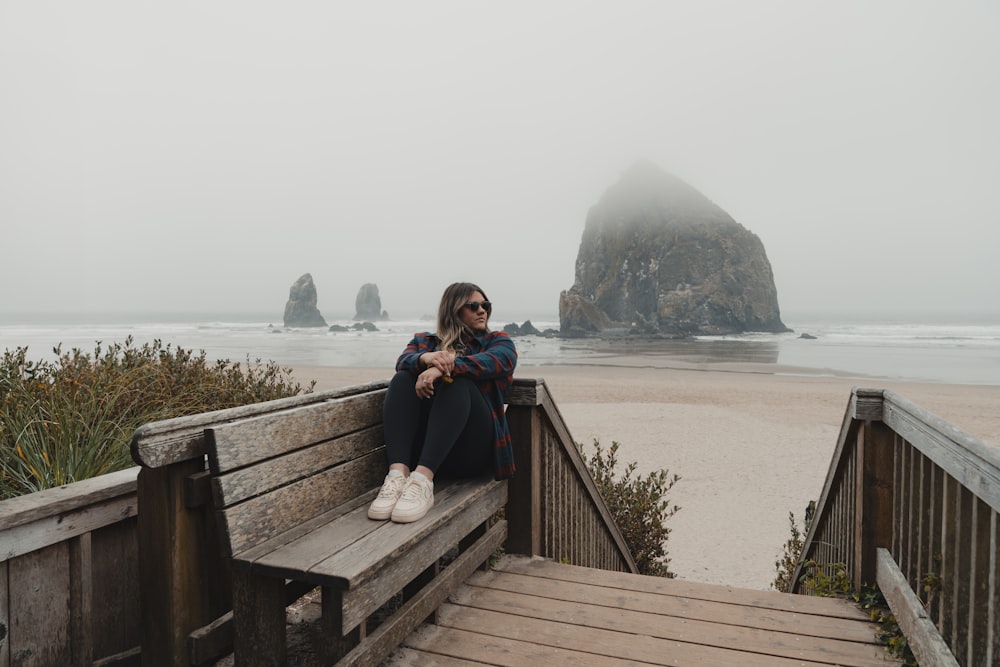 une femme assise sur un banc par un jour de brouillard