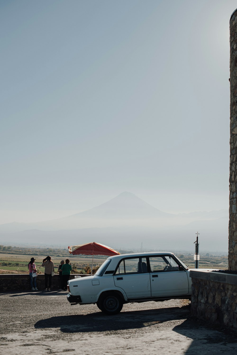 a white car parked in front of a stone building