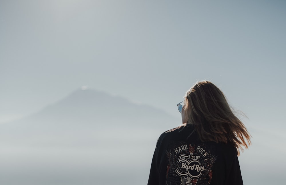 a woman looking at a mountain in the distance