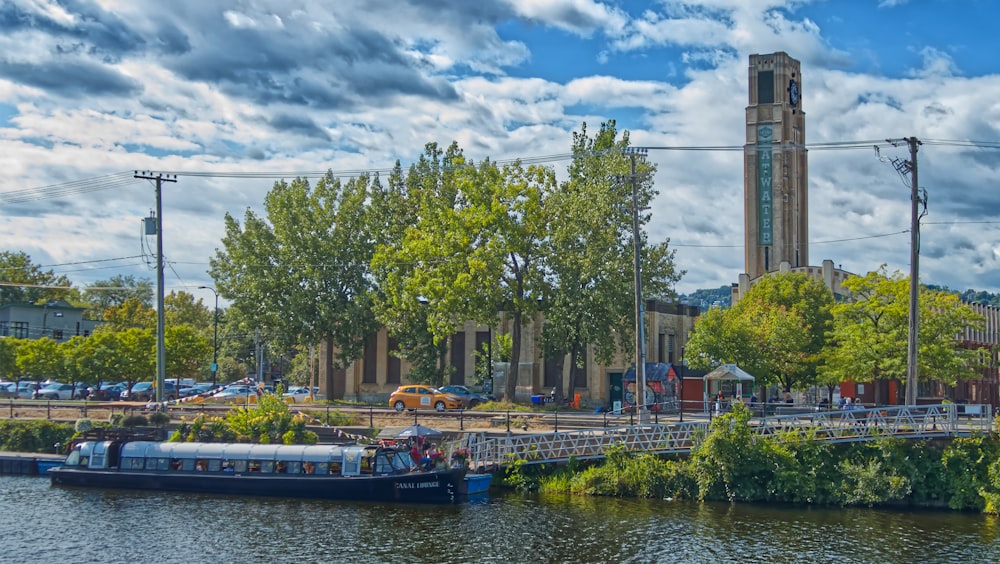 a boat on a river in front of a building with a clock tower