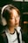 A person enjoying music through wireless headphones in a cozy living room setting.