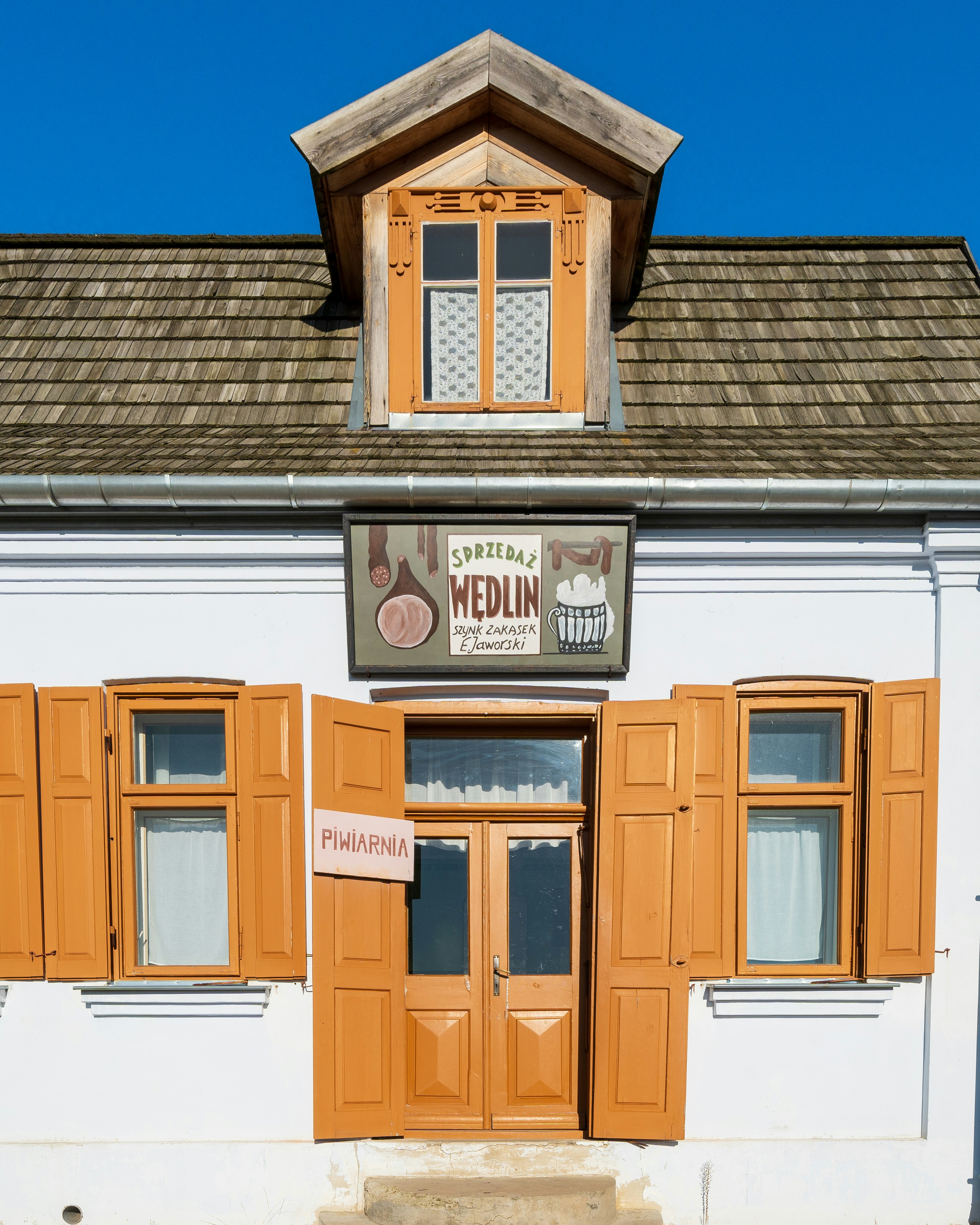 a white building with wooden shutters and windows