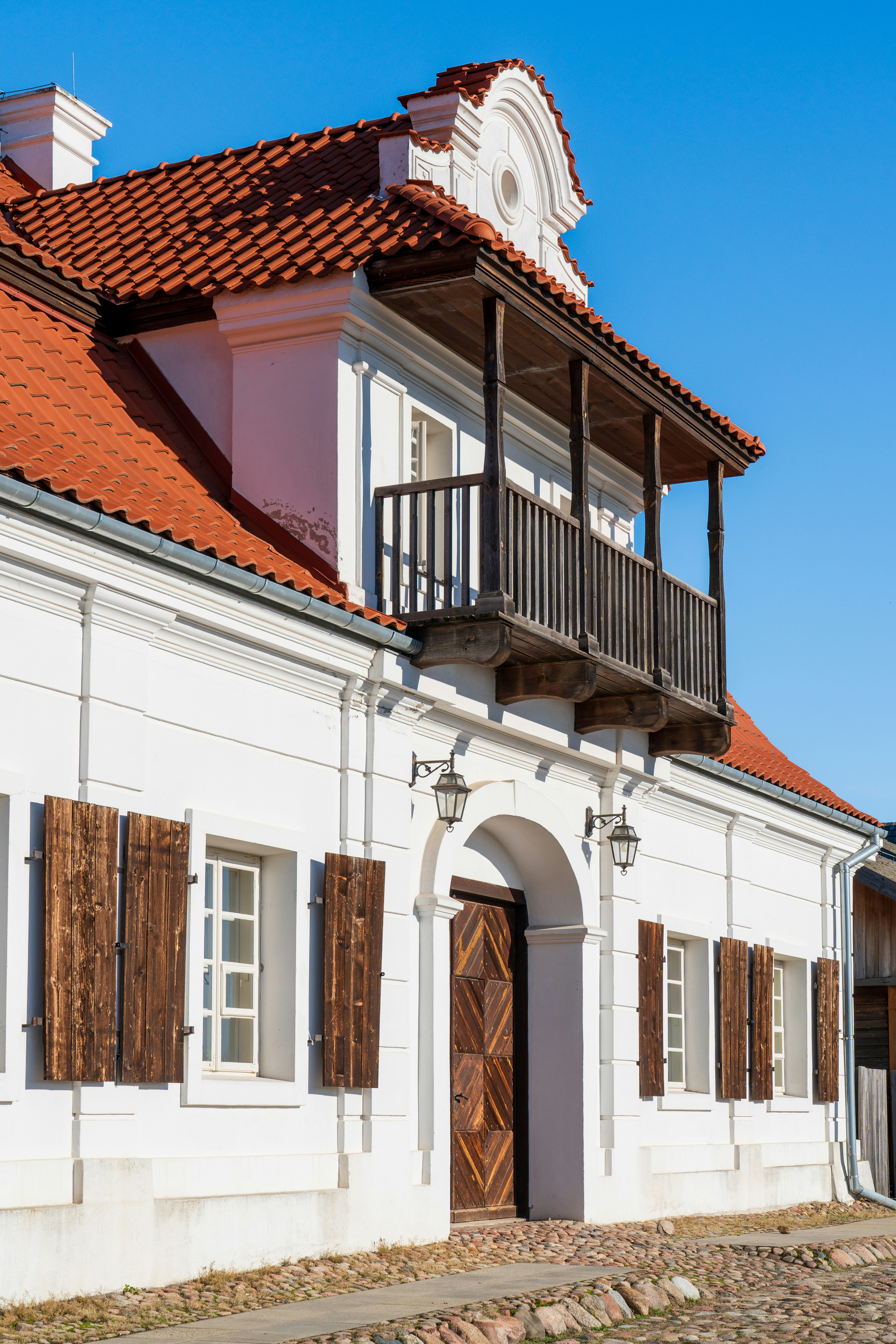 a white building with a red tiled roof