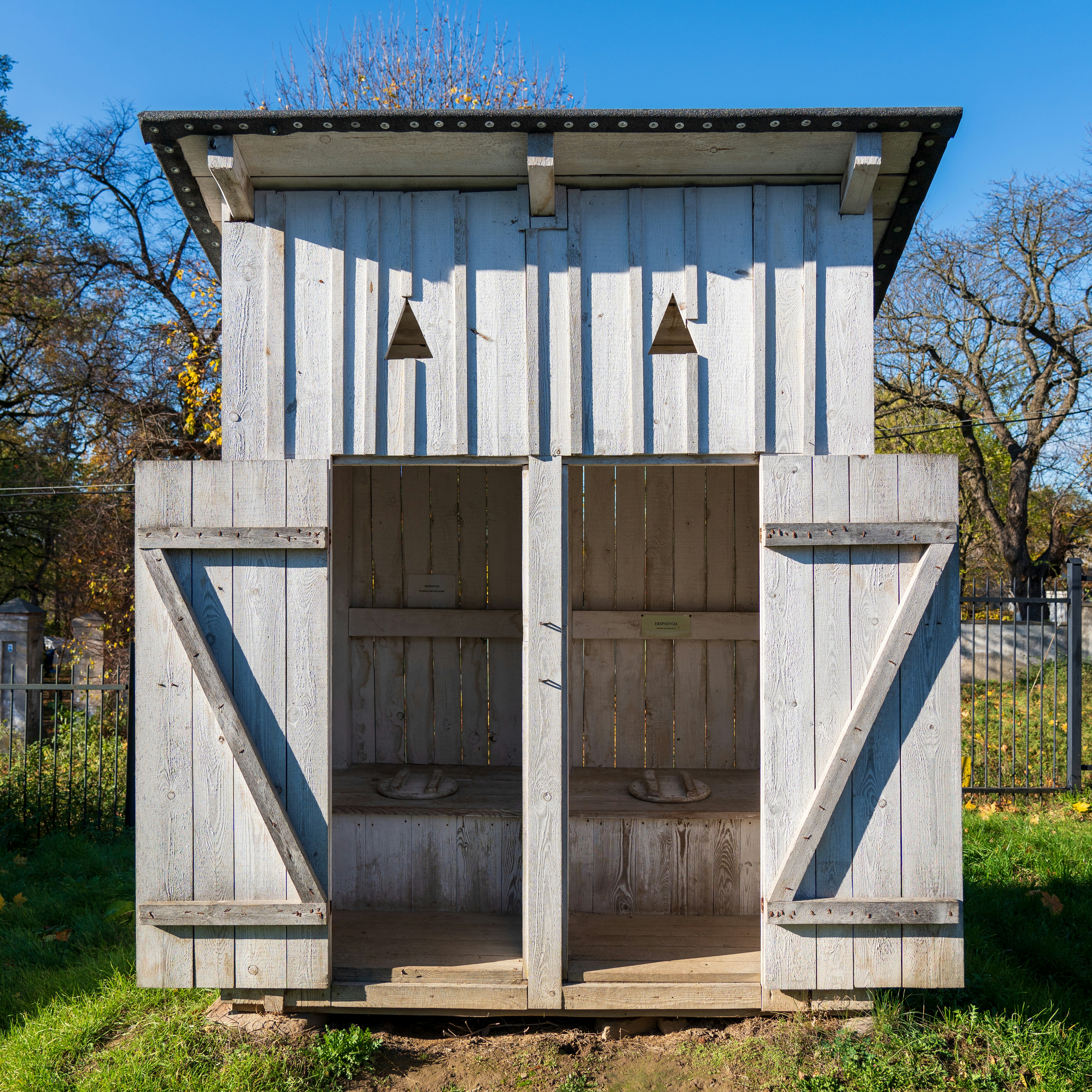 a wooden outhouse with two doors open